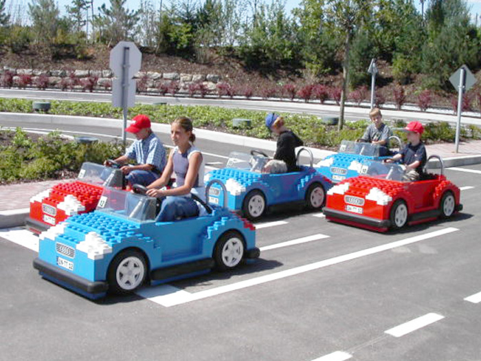 Children driving small cars at Legoland's Driving School attraction, designed for kids to learn basic road rules in a fun and safe environment