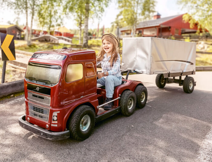 appy girl driving a truck at Hunderdorf Park, enjoying a fun and interactive experience in a playful environment