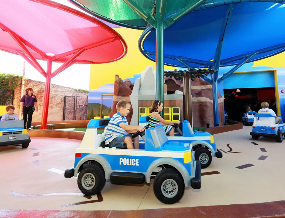 Children driving LEGO police cars at LEGOLAND Discovery Center, having fun in a playful and engaging environment