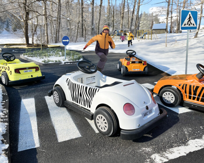 Children's driving school set in a winter landscape, featuring snow-covered surroundings and playful driving activities for kids