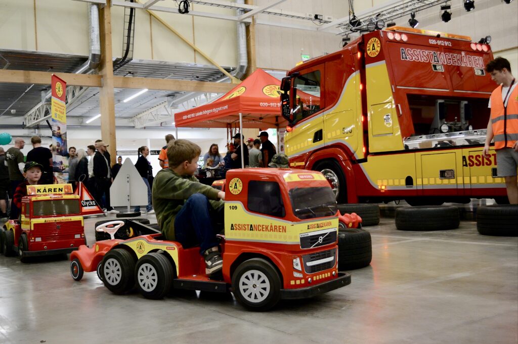 a boy driving a mini tow truck at a fair