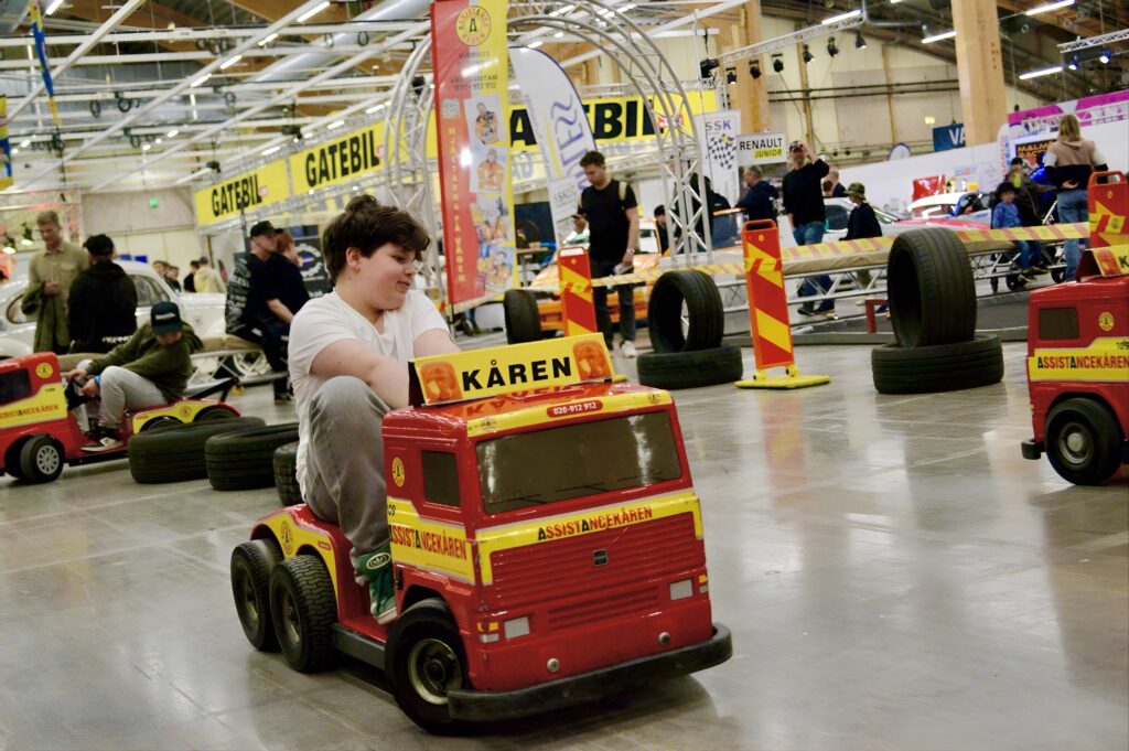a boy driving a mini tow truck